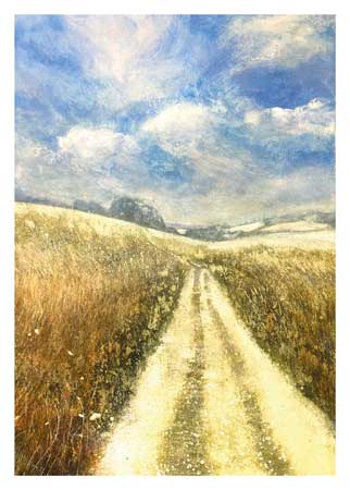 Dirt road through golden grass fields under a blue sky with scattered clouds.