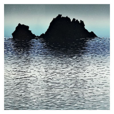 Silhouetted rocky island reflected in calm rippling water under a gradient sky.